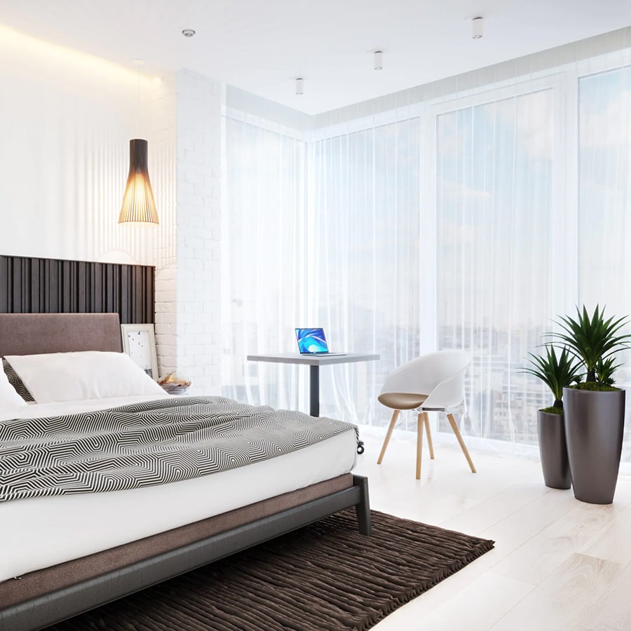 ein Schlafzimmer mit einem Bett, einem Tisch und Pflanzen