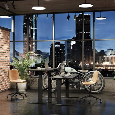 einen Schreibtisch und einen Stuhl in einem Raum mit einem Laptop und einem Motorrad im Hintergund